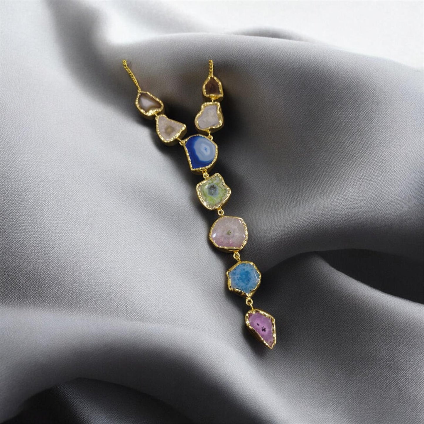Necklace with multicolored stones on a gray fabric background