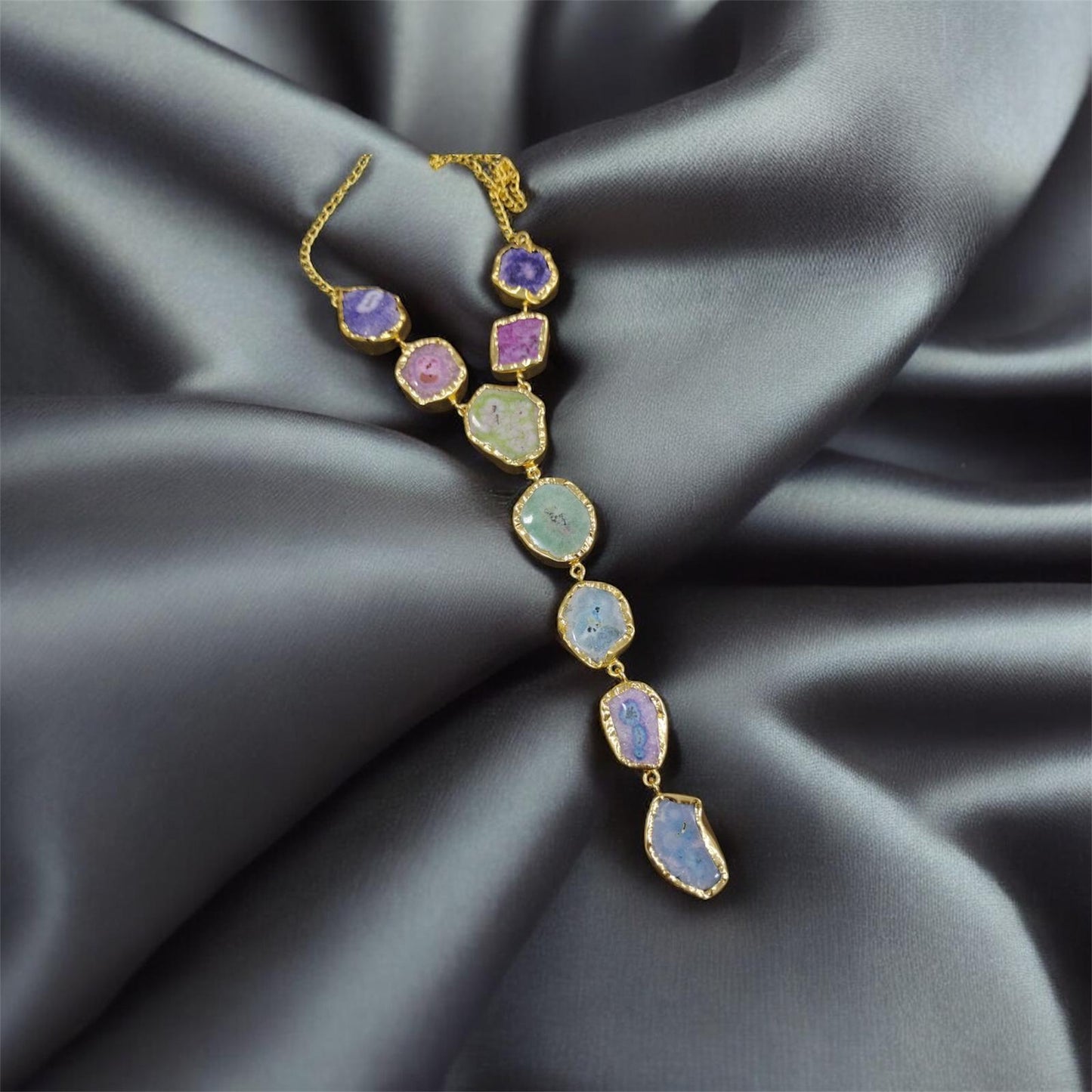 Multicolored gemstone necklace on a dark fabric background