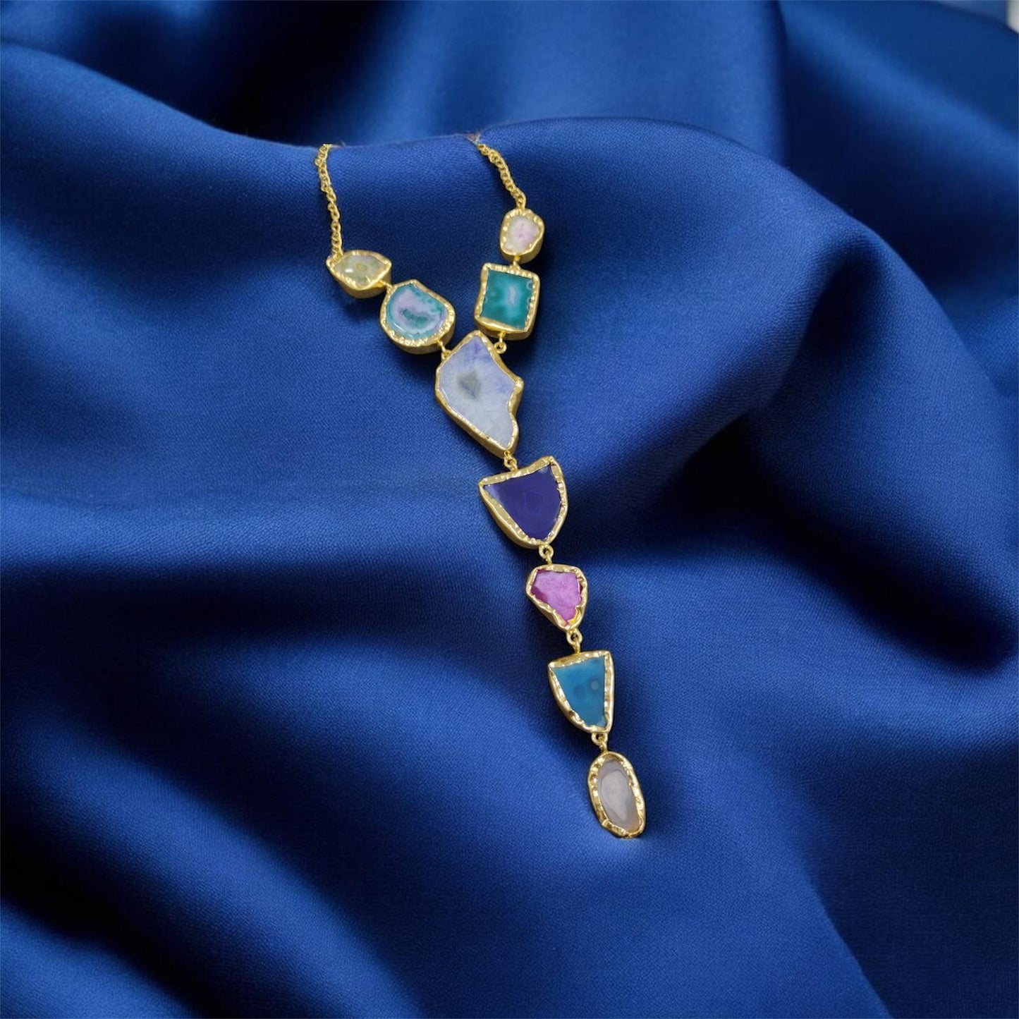 Necklace with multicolored gemstones on a blue fabric background