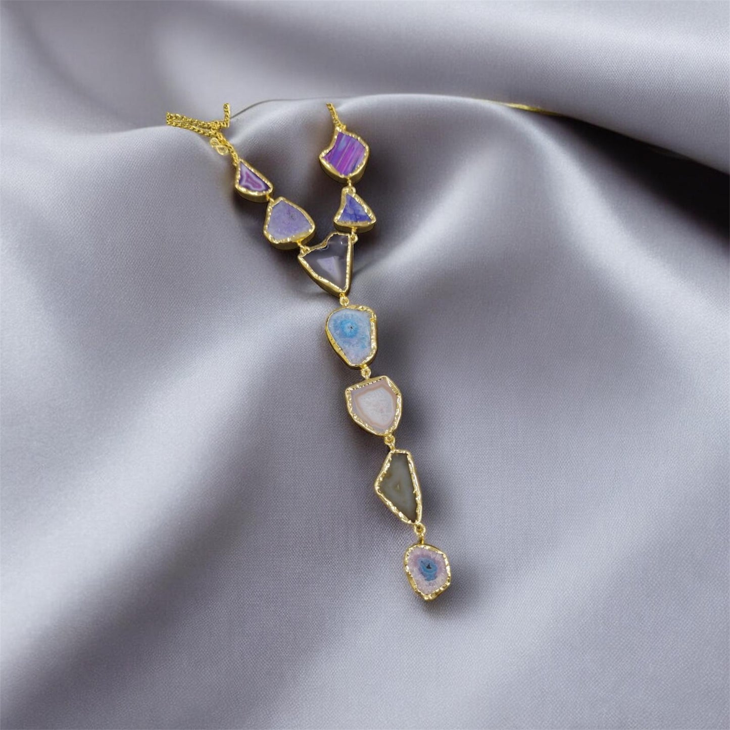 Necklace with colorful gemstones on a gray fabric background