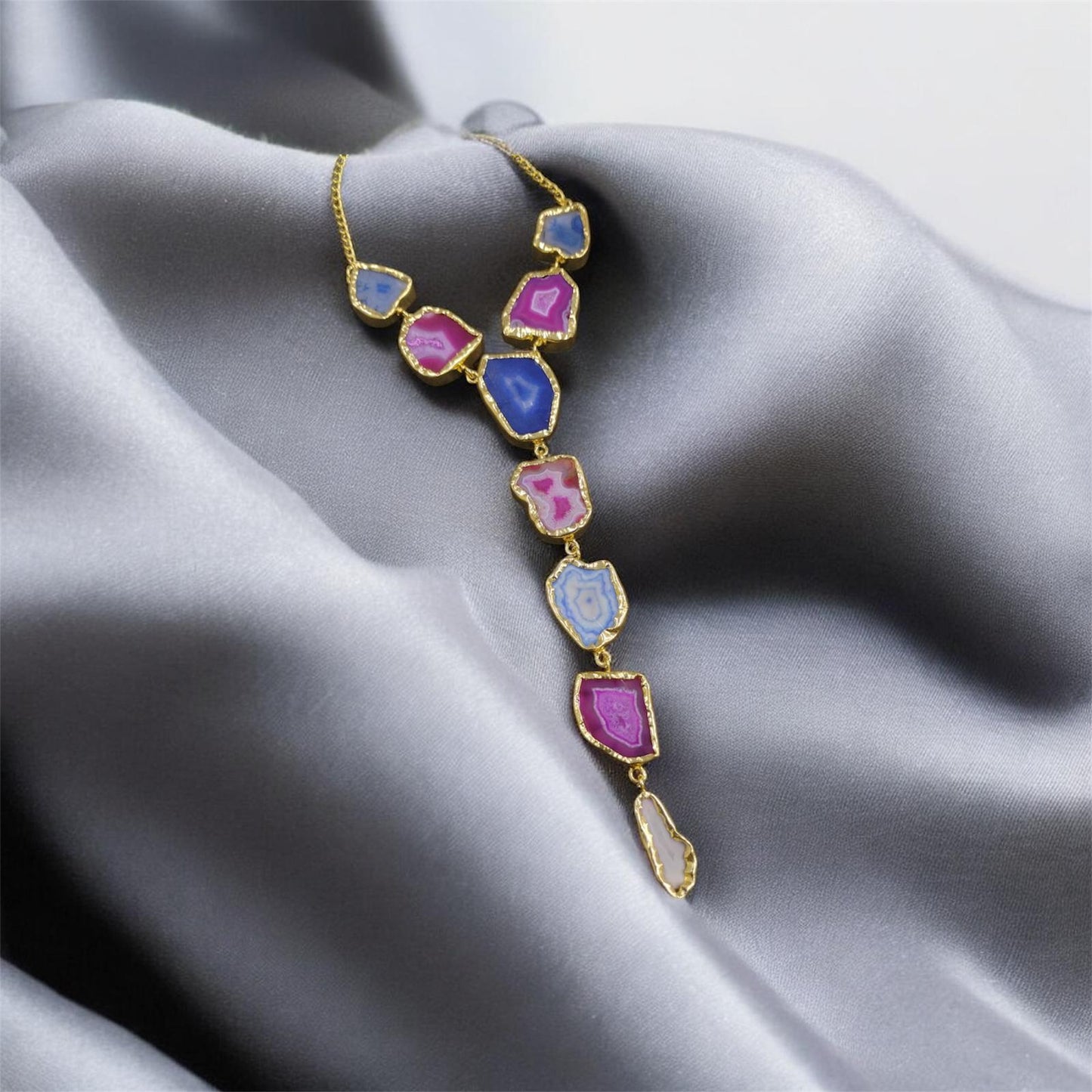 Necklace with colorful gemstones on a gray fabric background