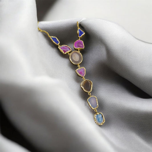 Necklace with multicolored gemstones on a gray fabric background