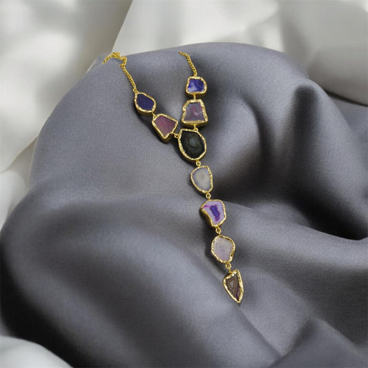 Necklace with multicolored stones on a gray fabric background