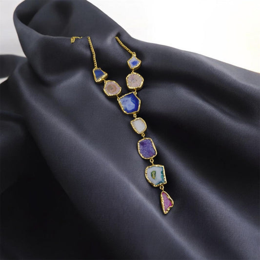 Necklace with multicolored gemstones on a dark fabric background