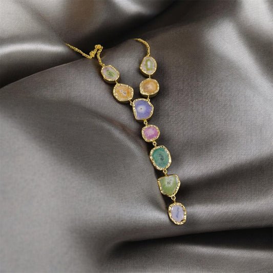 Multicolored gemstone necklace on a gray fabric background