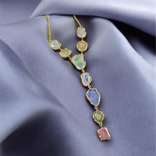 Necklace with colorful gemstones on a soft purple fabric background