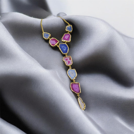 Necklace with colorful gemstones on a gray fabric background