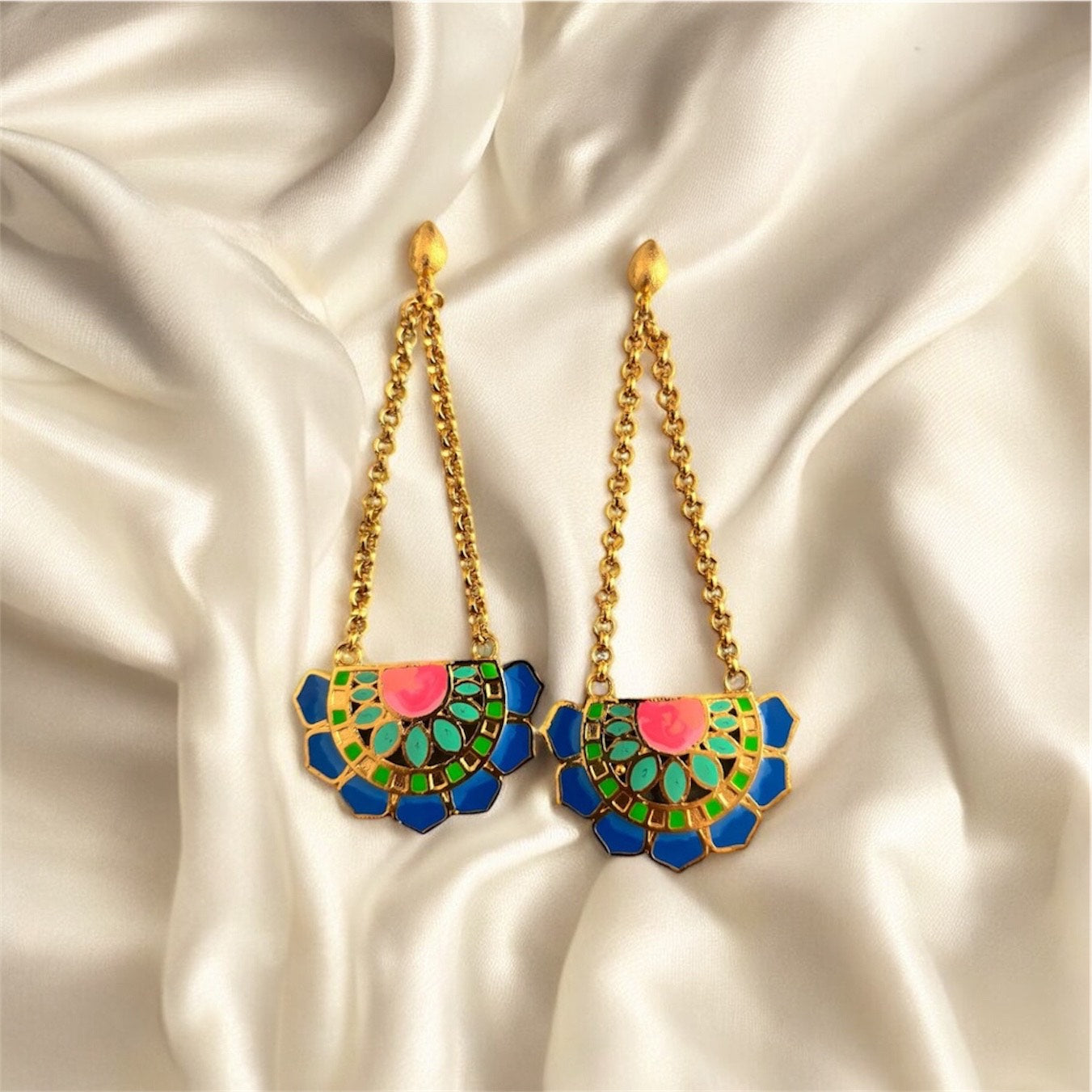 Colorful earrings with gold chains on a satin background. Blue Variant