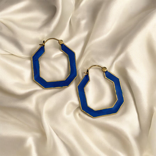 Blue hoop earrings on a satin surface