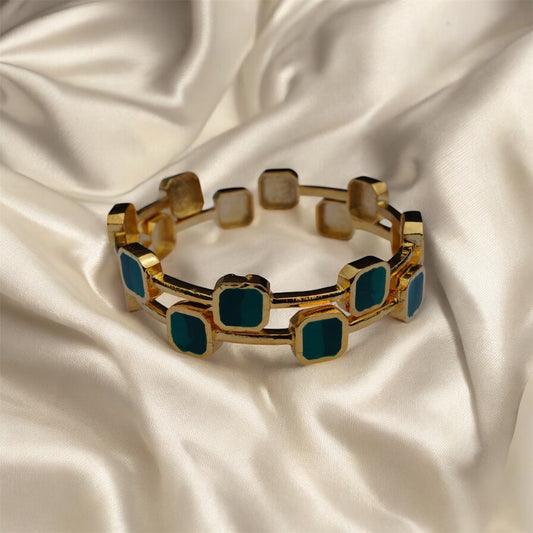 Gold bracelet with blue stones on a satin background