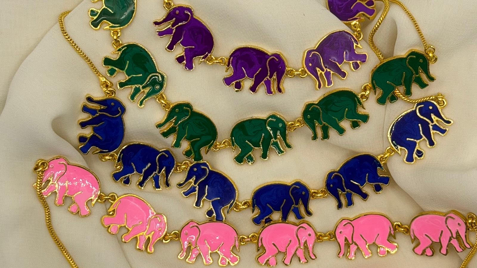 Necklace with colorful elephant pendants on a white surface