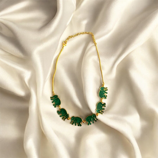 Necklace with green elephant pendants on a satin background