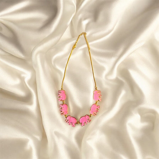 Neon pink necklace with gold chain on a satin background