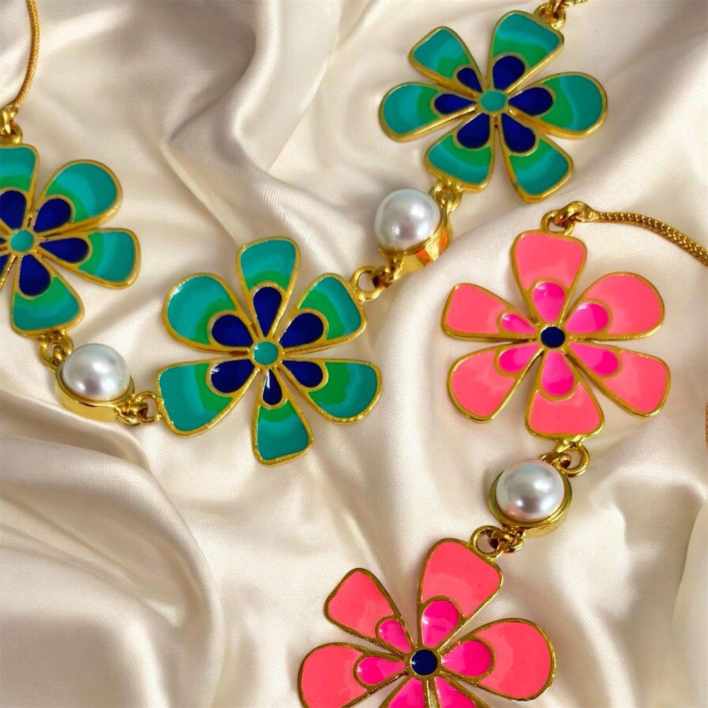 Flower-shaped jewelry set with colorful flowers and gold accents on a satin background