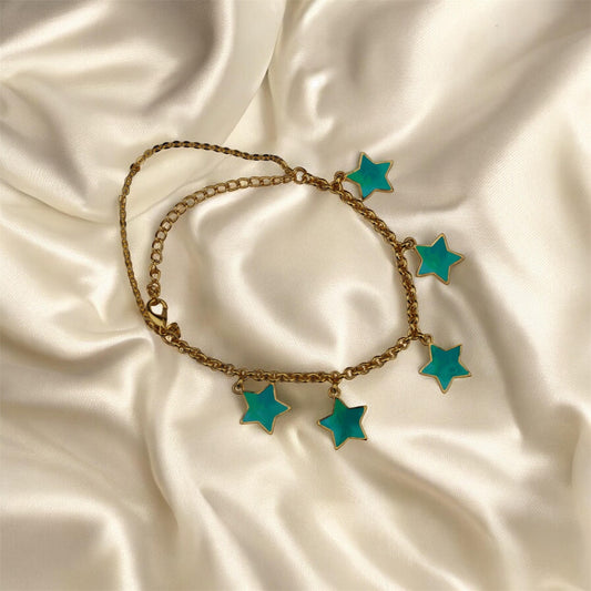 Bracelet with turquoise star charms on a satin surface