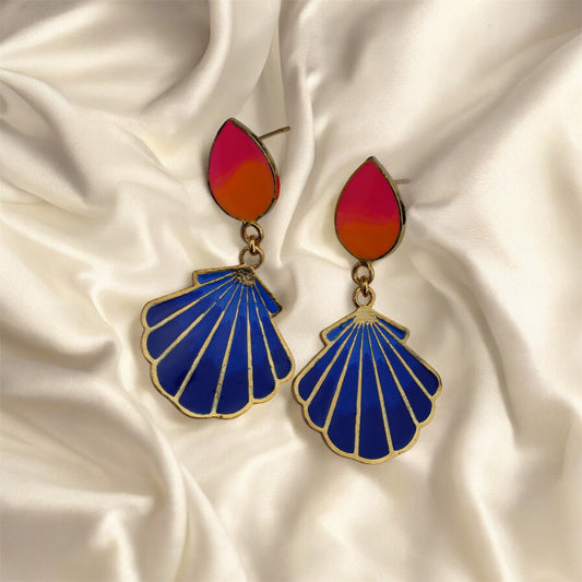 Pair of earrings with blue shell-shaped drops and pink and orange teardrop tops on a satin background.