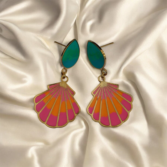 Colorful shell-shaped earrings on a satin background